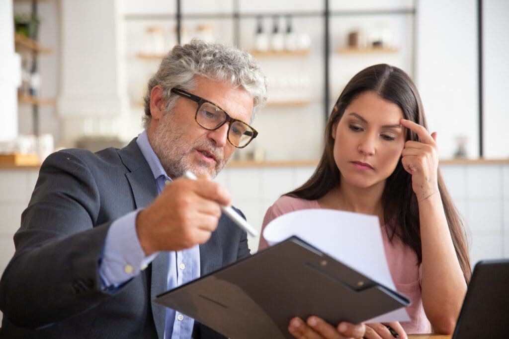 serious mature legal advisor reading analyzing explaining document female customer Founders